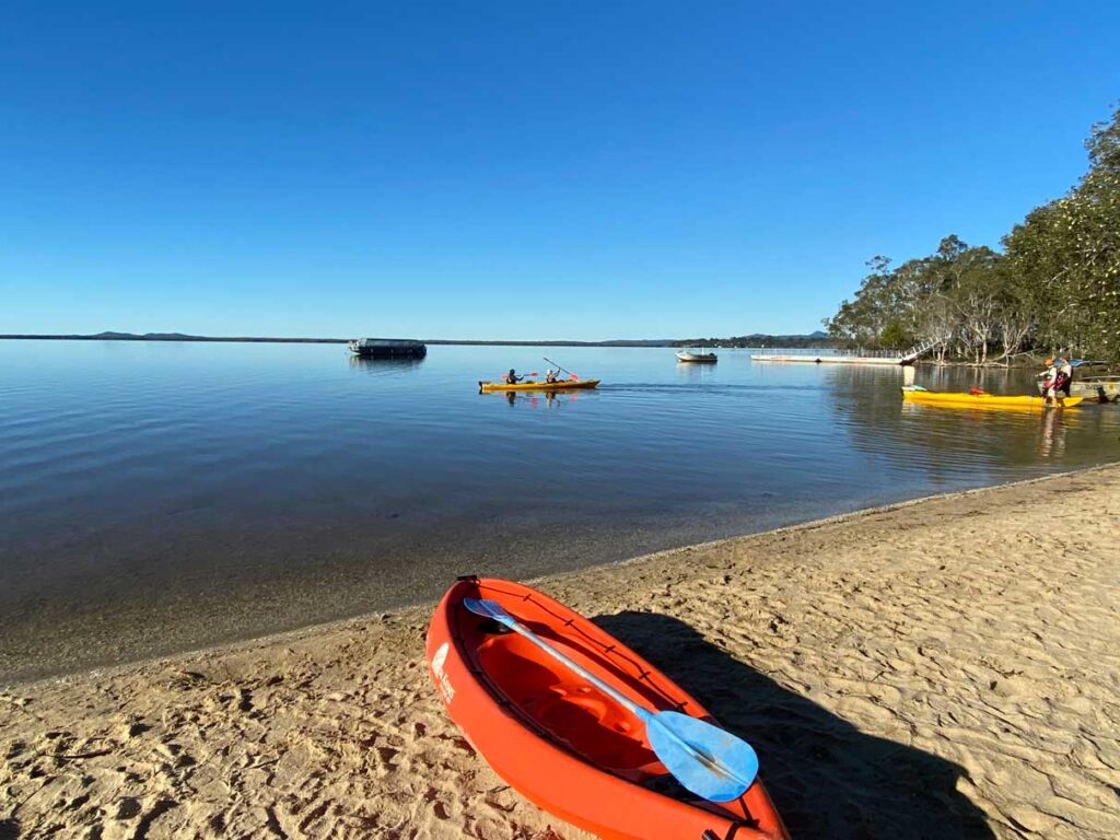 Picture of a canoe on the banks of a lake with blue sky